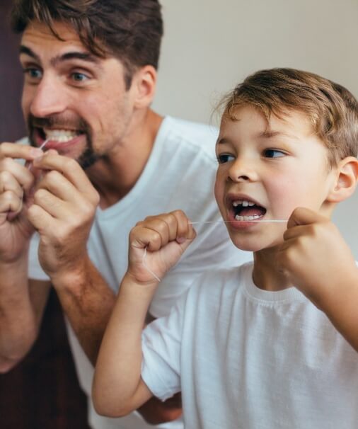Father teaching child good oral care techniques by flossing together