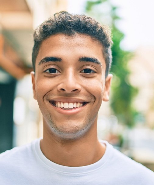 Closeup of teenage boy in white shirt smiling
