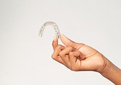 Closeup of teen holding clear aligner