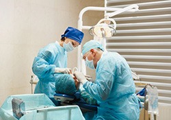 Dental team carefully performing oral surgery