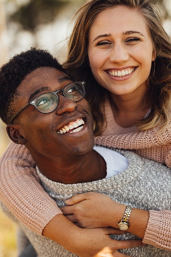 young couple smiling outside 