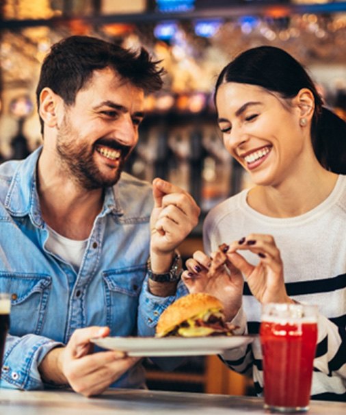 young couple enjoying beer and empanadas   