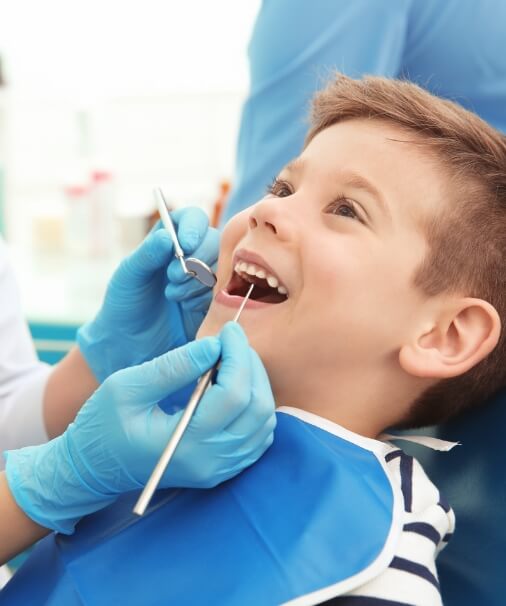 Child receiving dental checkup and teeth cleaning