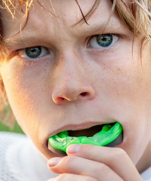 Teen placing an athletic mouthguard