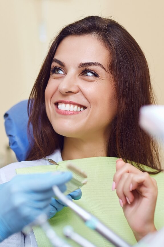 Woman with beautiful smile after dental crown restoration