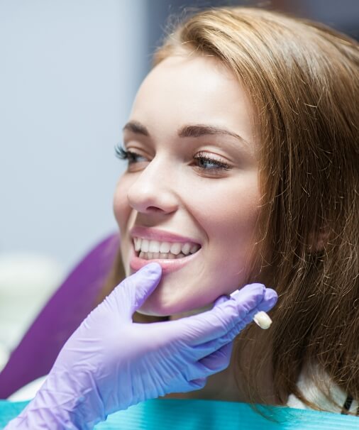 Dentist examining patient's smile after dental crown treatment