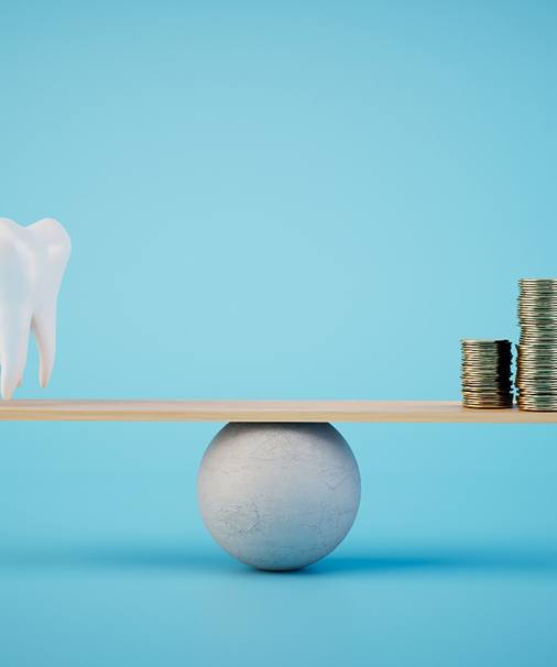 A scale on which a model tooth and stacks of coins are balanced