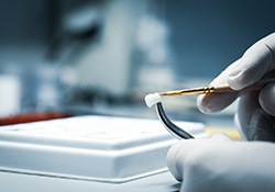 A lab worker processing and making a dental crown