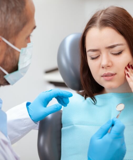 Woman in dental chair to receive emergency dentistry treatment