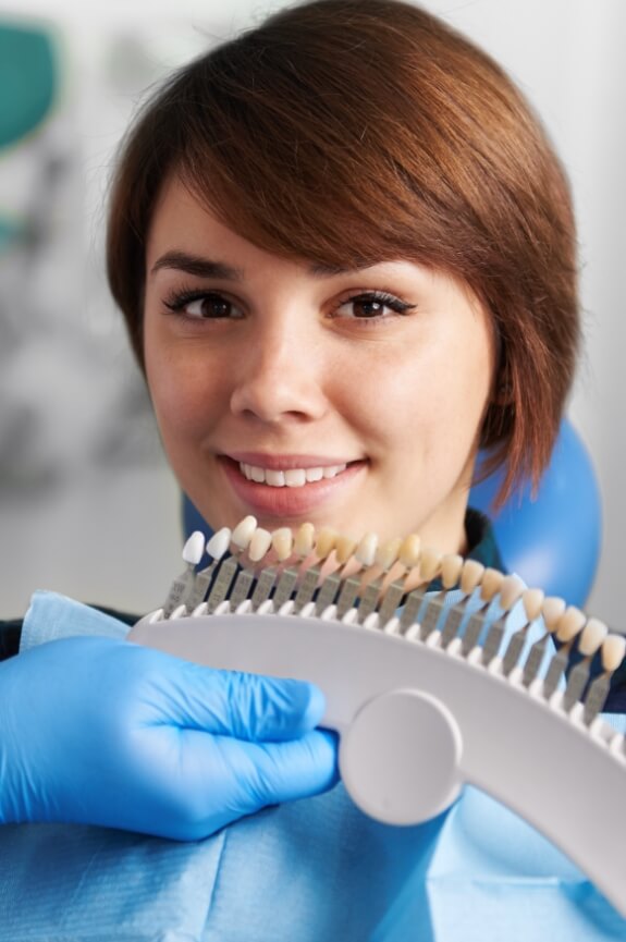 Woman's smile compared with tooth colored filling shade options