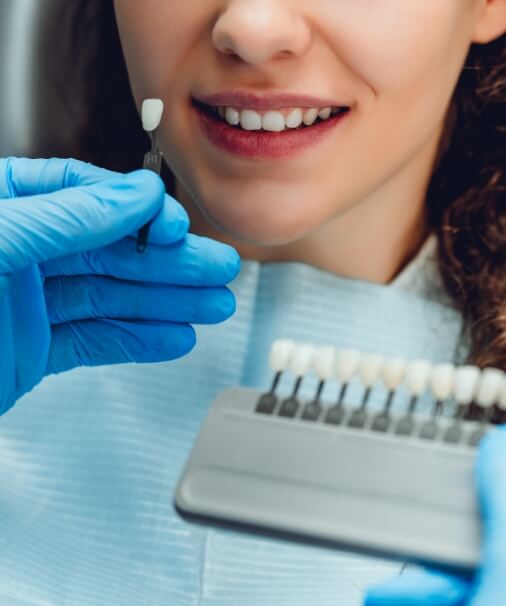 Dentist examining patient's smile after tooth colored filling procedure