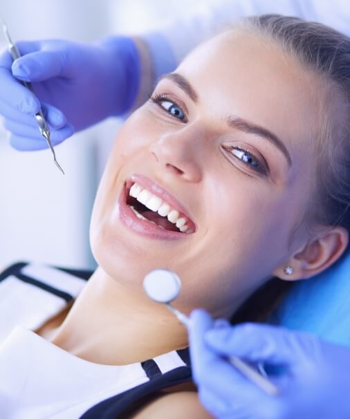 Woman smiling after full mouth reconstruction treatment