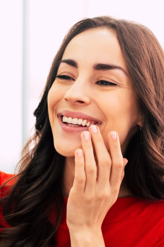 Woman admiring her smile after tooth replacement with dental implants