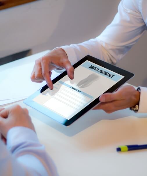 Dentist and patient reviewing dental insurance forms