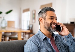 Man smiling while talking on phone at home