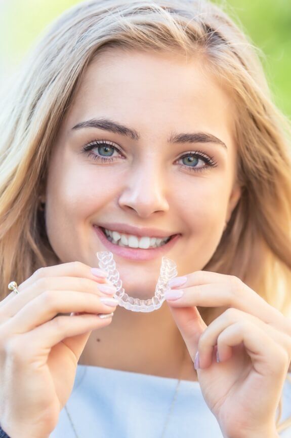 Woman placing an Invisalign tray