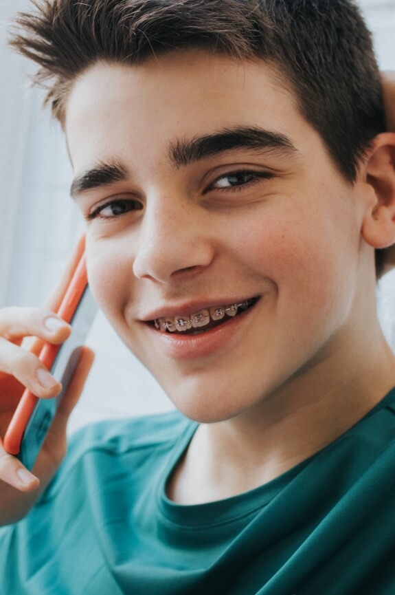 Smiling teen with traditional orthodontics