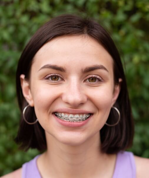 Woman receiving orthdontics treatment smiling outdoors