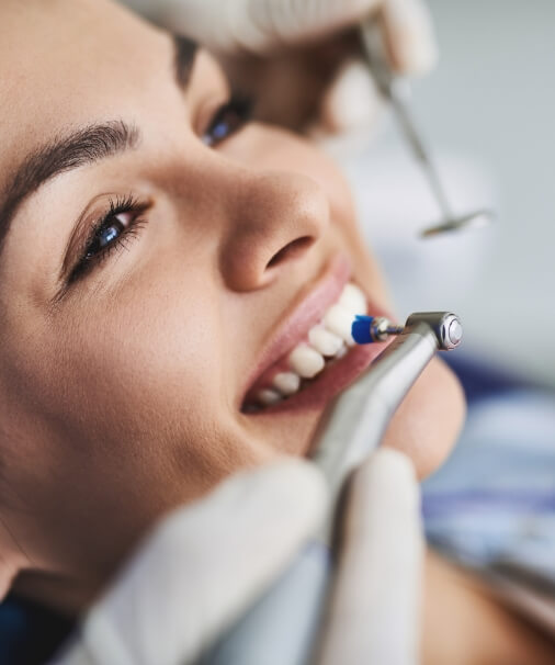 Woman receiving dental checkup and teeth cleaning