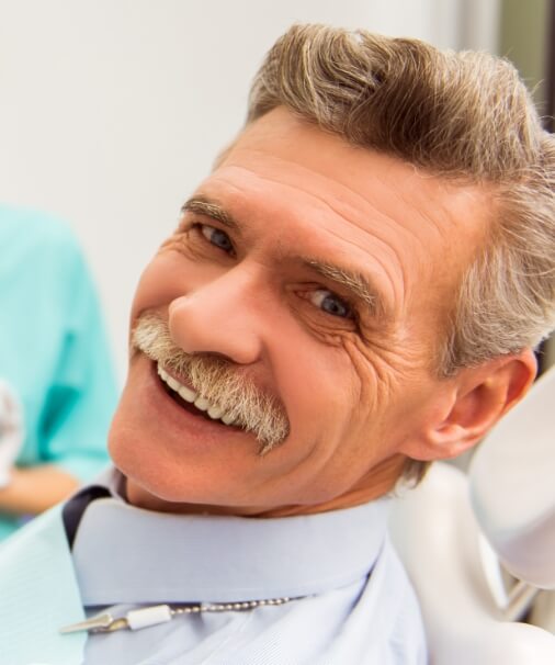 Man with dentures sharing healthy smile
