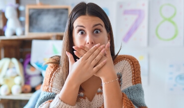 Woman in need of emergency dentistry covering her mouth