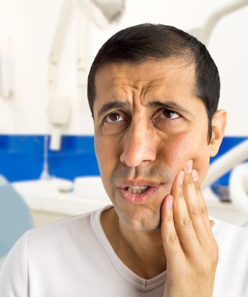 Man experiencing oral and facial pain caused by T M J dysfunction