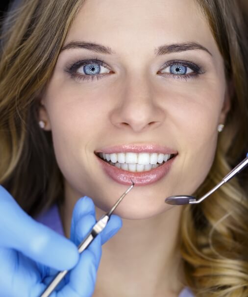 Dentist examining patient's smile after teeth whitening