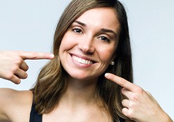 Woman pointing to her smile