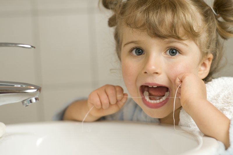 Girl using dental floss