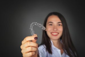 Woman holding Invisalign aligner