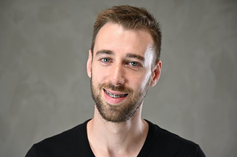 A man smiling with adult braces