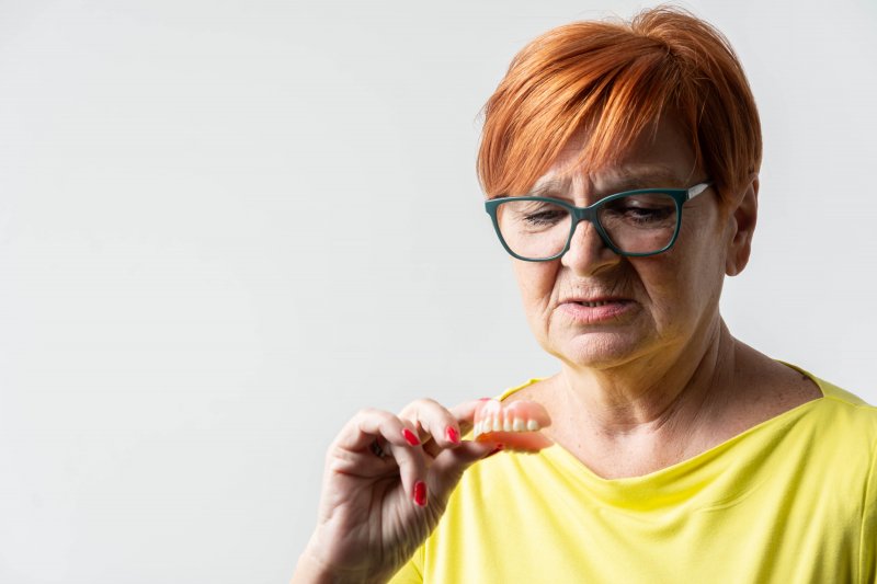 Patient looking at a botched DIY denture reline